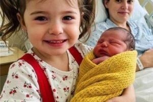 MY DAUGHTER WAS THRILLED TO HOLD HER NEWBORN SISTER